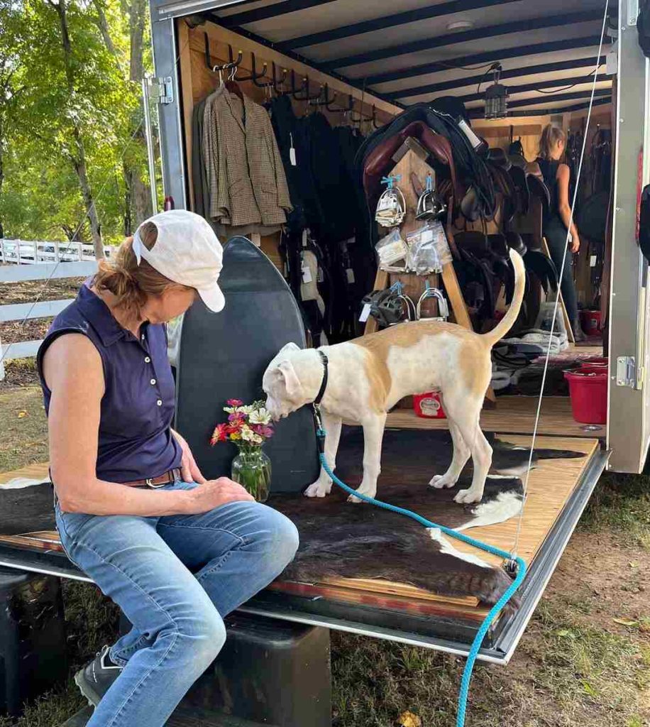 Dog sniffing flowers at tack trailer